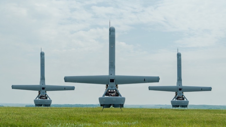 Three Shield AI MQ-35 V-BAT drones floating vertically