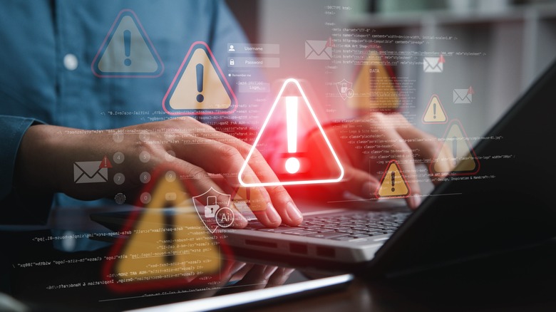 person typing on laptop with warning alert graphic overlay