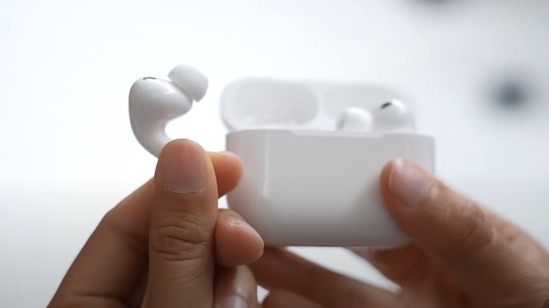A person holding Apple AirPods Pro 3s.