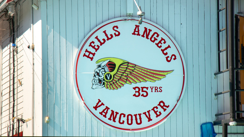 A hells angel logo mounted on the side of a white warehouse in Vancouver