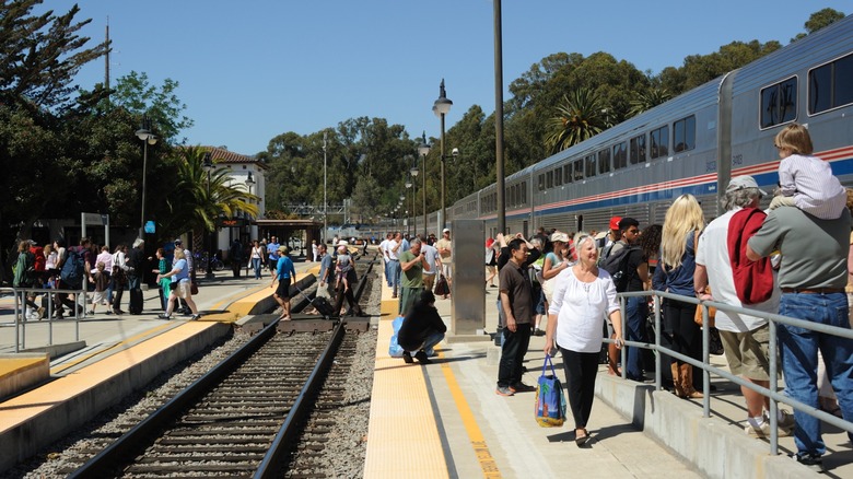 Travelers boarding and departing a passenger train