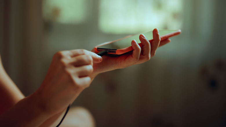 Person plugging a type-C cord into an Android smartphone