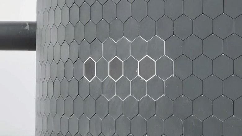 View of a portion of Starship's heat shield with three experimental metallic tiles.