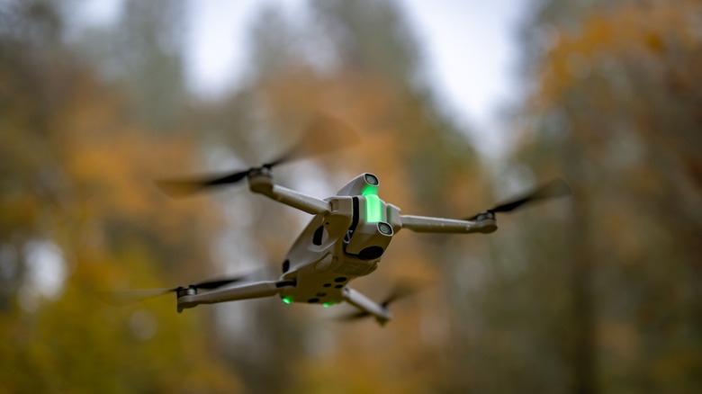 The Antigravity A1 flying with out of focus trees in the background.