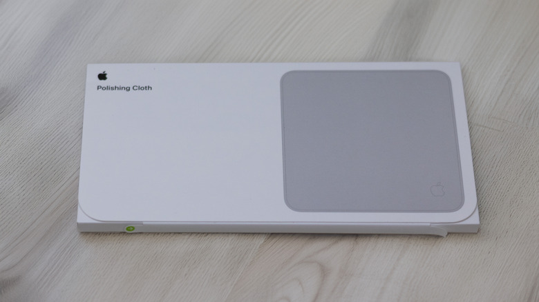 Letterbox packaging of Apple's polishing cloth placed on top of a gray wooden surface.