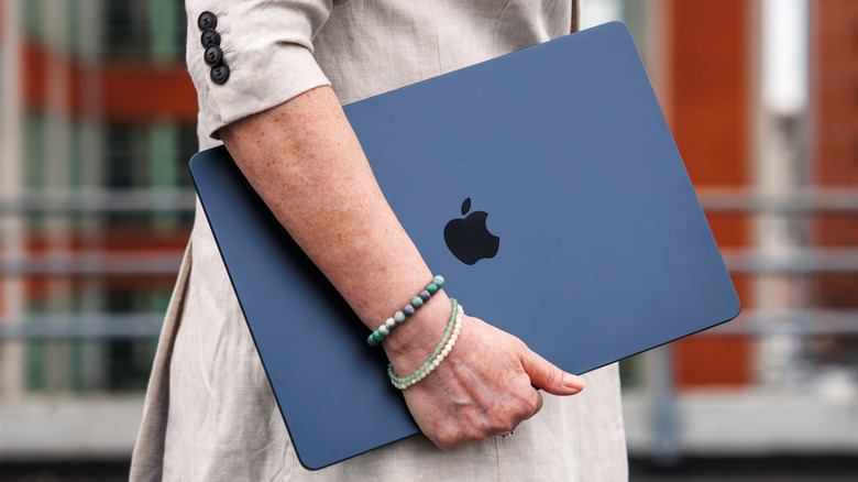 Person carrying a MacBook Pro