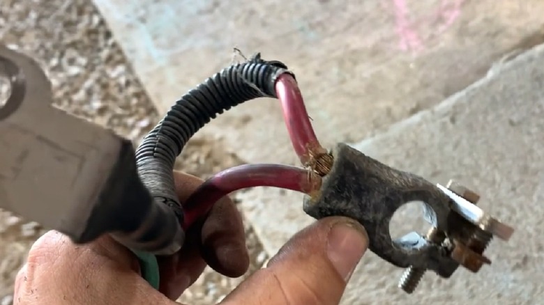 A worn battery cable terminal showing bare wires