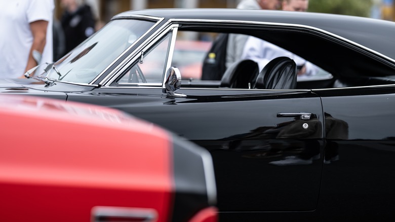 Door and roofline of a black Dodge Charger parked at car show