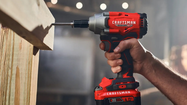 person using a Craftsman half-inch impact driver on wood pieces