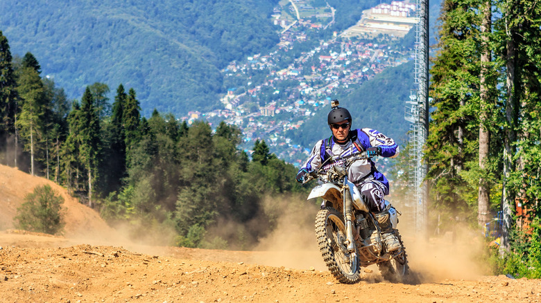 Man rides his motorbike with gopro camera on the helmet on sunny day.