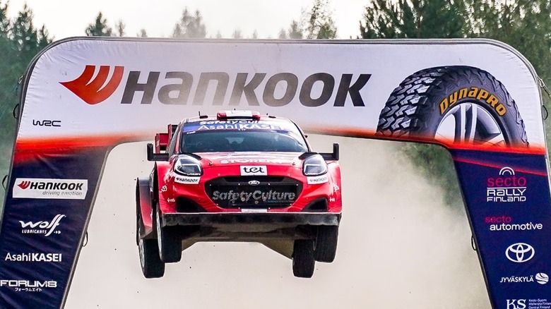 WRC Rally car in Finland flying through air in front of Hankook tire sign