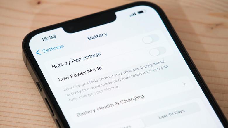 iPhone on wooden surface with battery management screen open