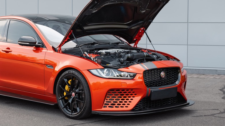 An orange Jaguar Project 8 with its hood opened.