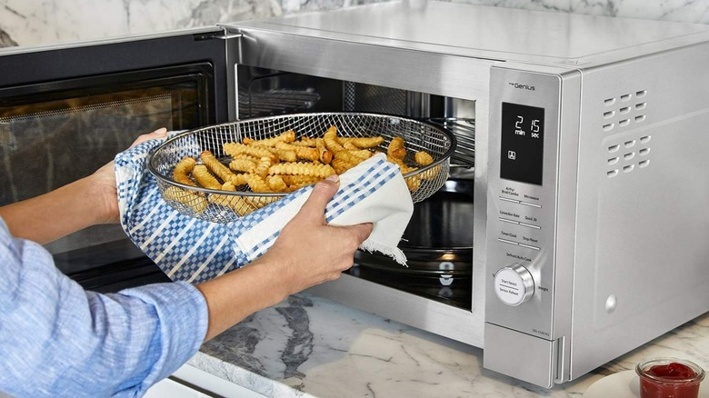 A person taking fries out of a Panasonic combination microwave