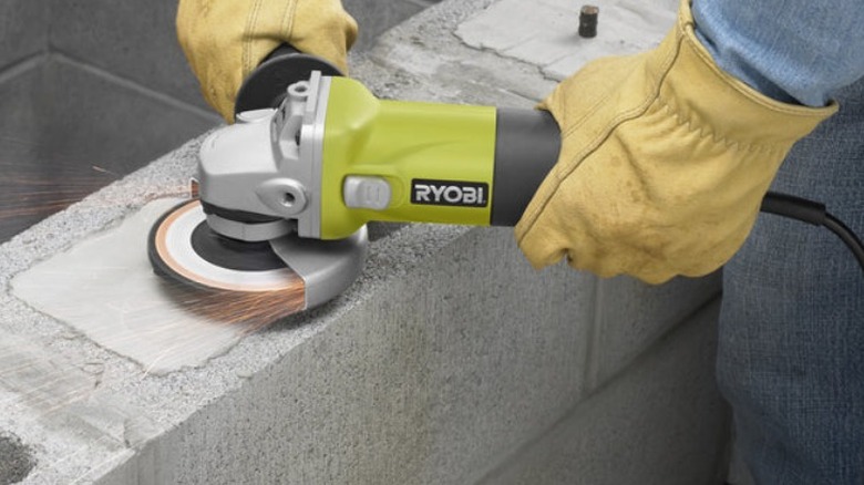 Person using Ryobi Angle Grinder on concrete