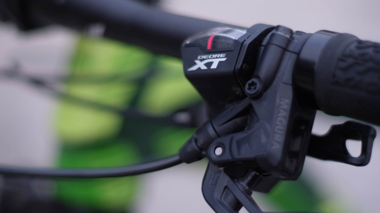 a Close up shot of Shimano XT brakes mounted on a green bike.