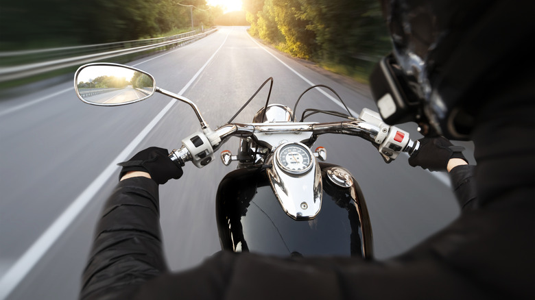 A motorcycle riding on an empty road.