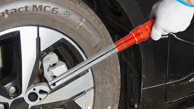 A person using a Vevor torque wrench on a car.