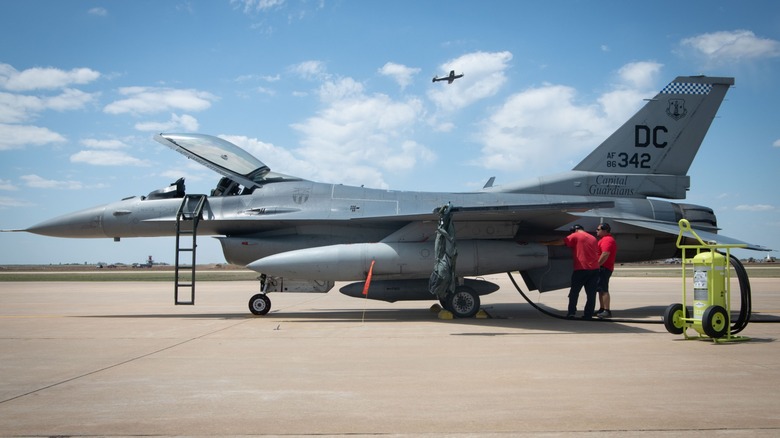 Workers refueling an F-16 on a tarmac