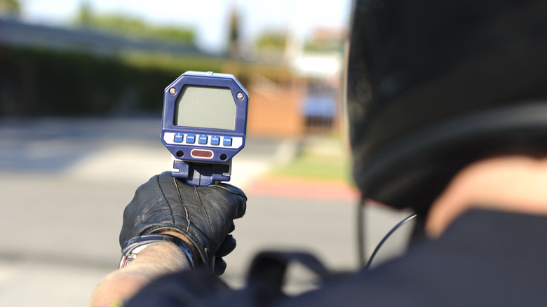 Police officer pointing a speed camera
