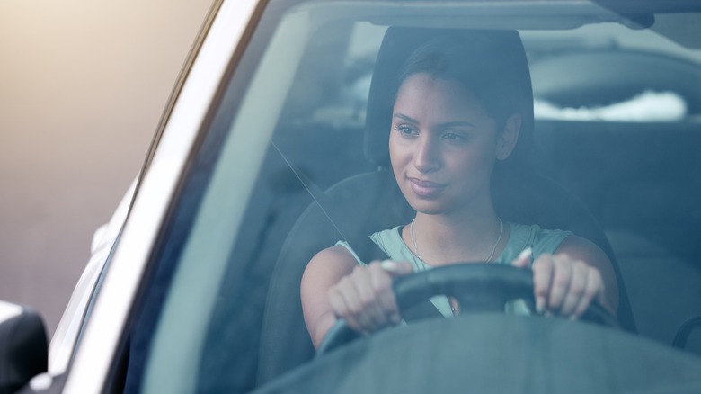 Confident-looking driver checking her side mirror
