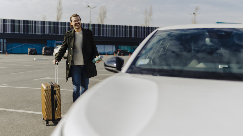 man walking to his rental car