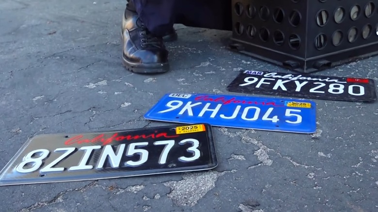 Three wrapped California license plates on the ground.