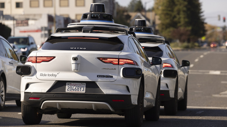 Waymo taxis waiting at a light.