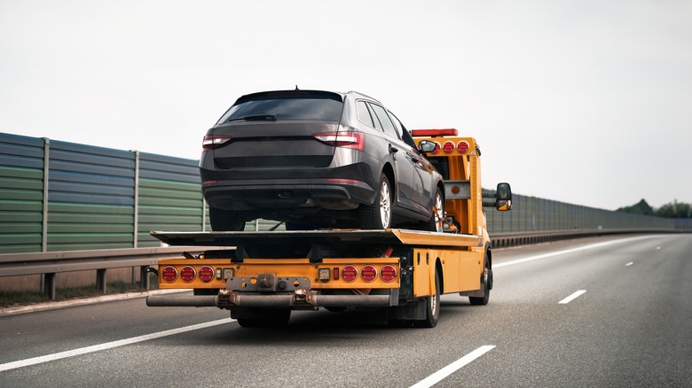 A car being towed down the road.