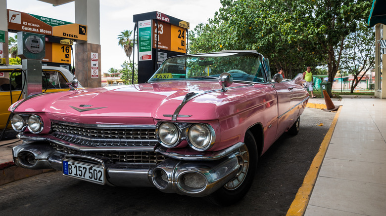 A pink 1959 Cadillac Eldorado Biarritz filling up at gas station
