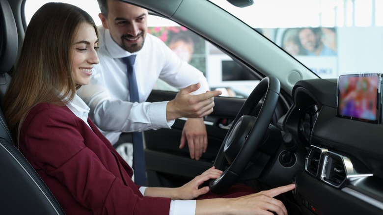 Salesman and client trying a car