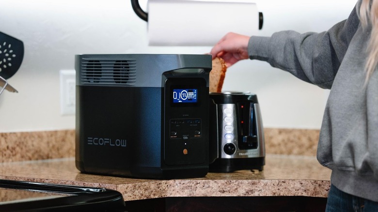 Woman using toaster next to EcoFlow battery generator