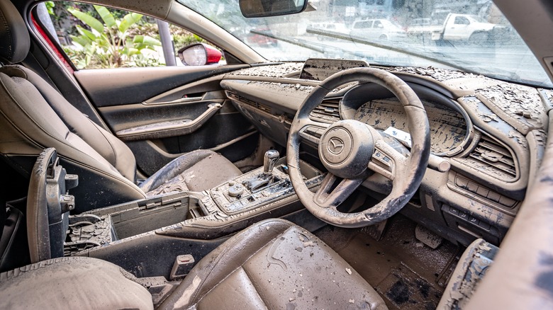 A modern Mazda interior covered in mud.