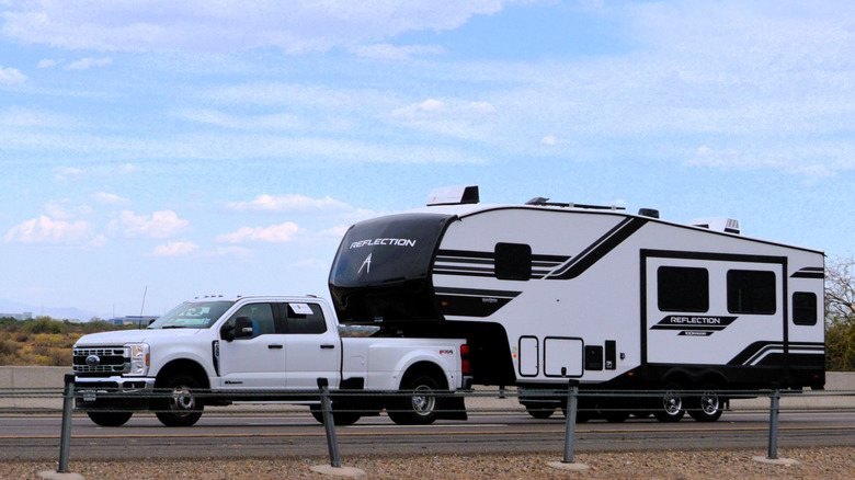 Pickup truck with RV trailer hooked up to third-wheel mount