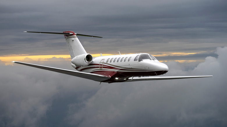 A private jet flies high above the clouds