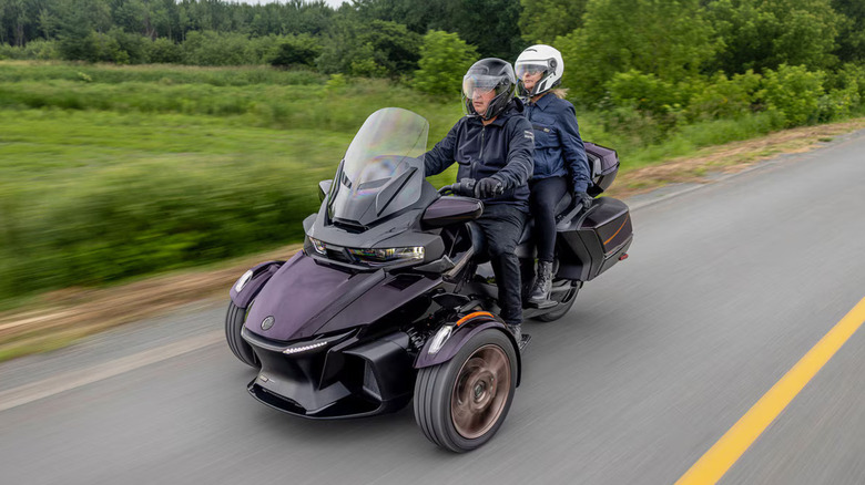 A purple 2025 Can-Am Spyder RT on the move with two passengers
