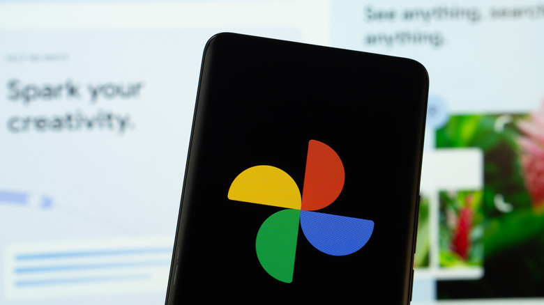 Google Photos logo on smartphone with Google Photos website in background