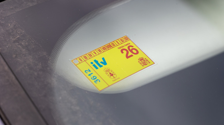 A Spanish roadworthiness sticker on an unidentified dusty windshield