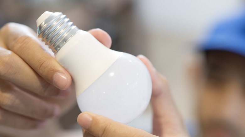 A person holding an LED light bulb.