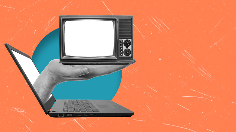 hand extending out of a laptop, holding an old TV