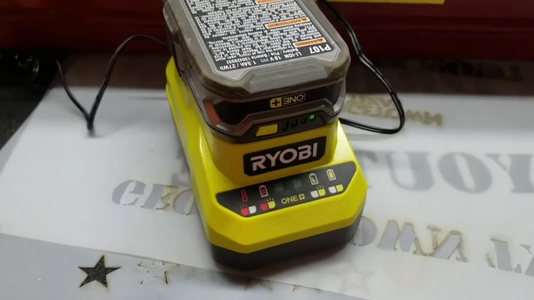 A Ryobi battery attached to a charger.