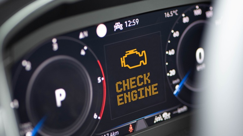 a car dashboard displaying the check engine light