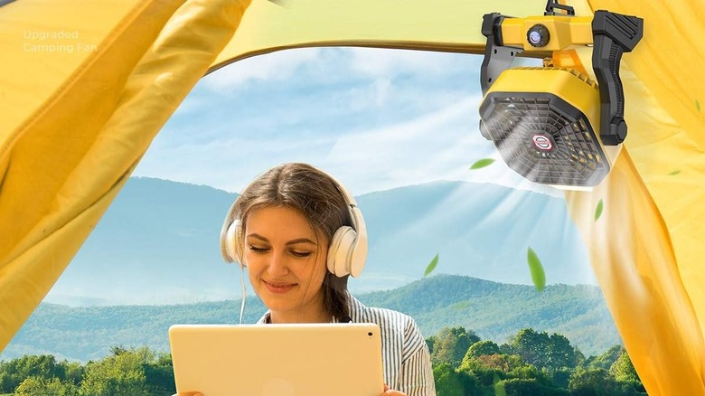 woman camping with fan