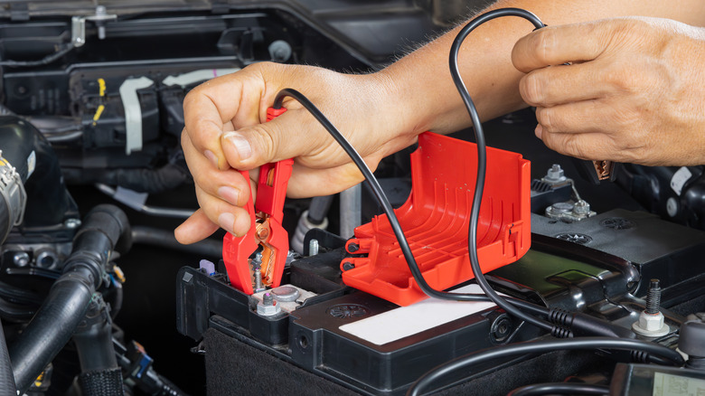 Mechanic testing the charge on an AGM car battery