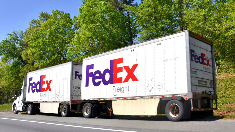A FedEx truck pulling two trailers