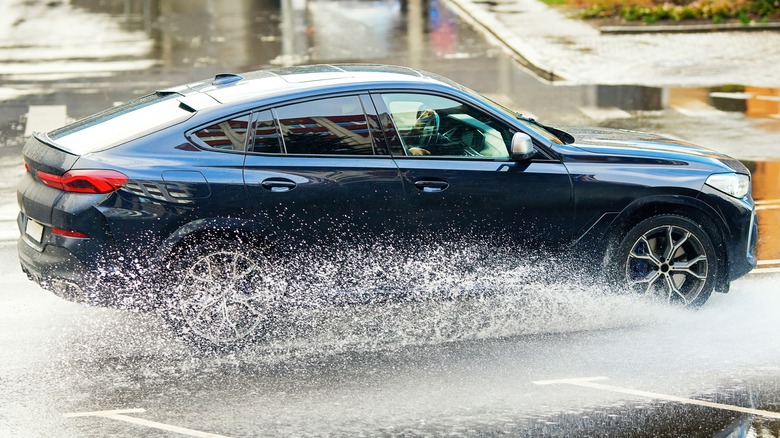 Blue SUV driving through a puddle