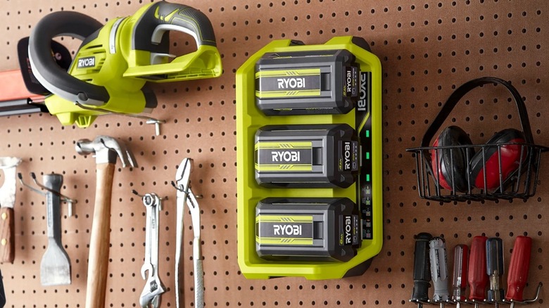 Ryobi's 40V 3-Port Sequential Fast Charger mounted on pegboard behind a workbench.
