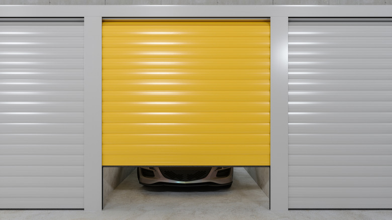 A partially opened storage until with a parked car inside.