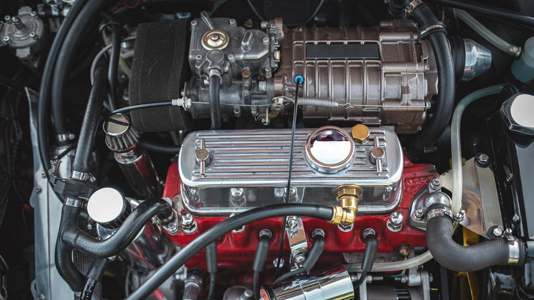 A small supercharged engine in a vintage car engine bay