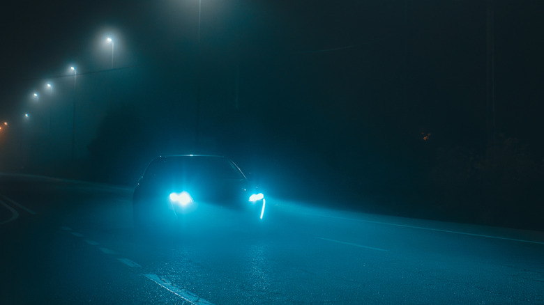 car with bright bluish led headlamps on the highway